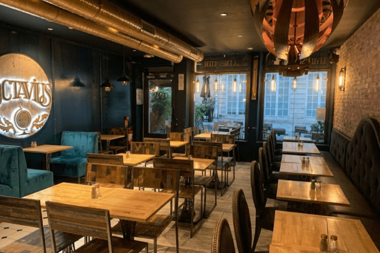 Vue de la salle intérieure élégante d'Octavius Burger à Nancy avec ses banquettes en velours, ses tables en bois sombre et son cadre chaleureux à deux pas de la Place Stanislas.